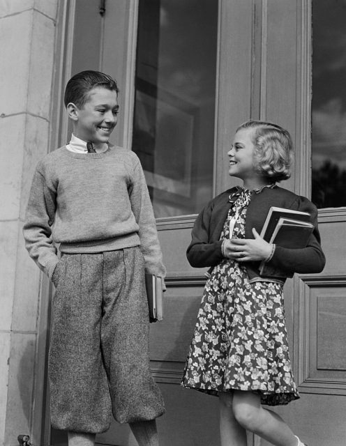 1940s SMILING BOY & GIRL HOLDING SCHOOL BOOKS BY DOORS (Photo Credit: H. Armstrong Roberts/ClassicStock/Getty Images)