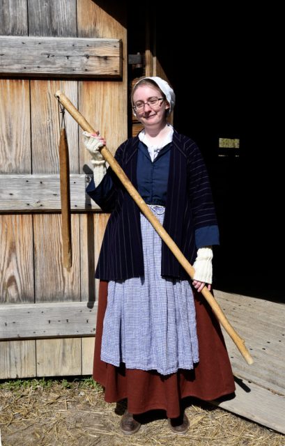 A guide in period costume stands at the entrance to the recreated 16-sided barn at Mount Vernon, the plantation owned by George Washington, the first President of the United States, in Fairfax County, Virginia, near Alexandria. The guide is holding a flail, an early threshing tool used to separate wheat from chaff.  (Photo Credit: Robert Alexander/Getty Images)