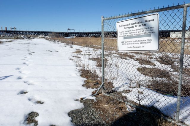 Snow-covered grass blocked off by a chainlink fence