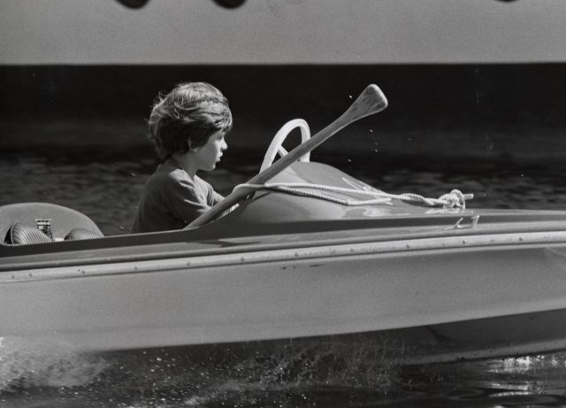 JFK Jr. driving a motor boat 