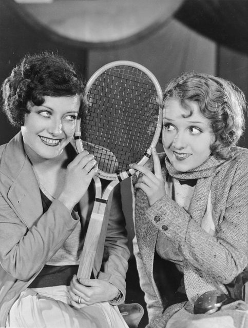 Joan Crawford and Anita Page holding a tennis racket
