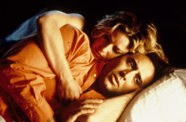 Elisabeth Shue embracing Nicolas Cage from behind while they are both lying down.