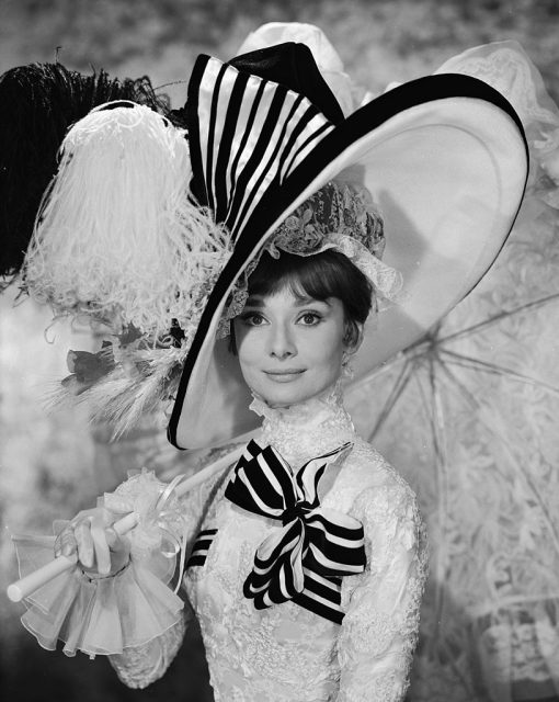 Eliza Doolittle wearing an extravagant black and white outfit and holding a parasol