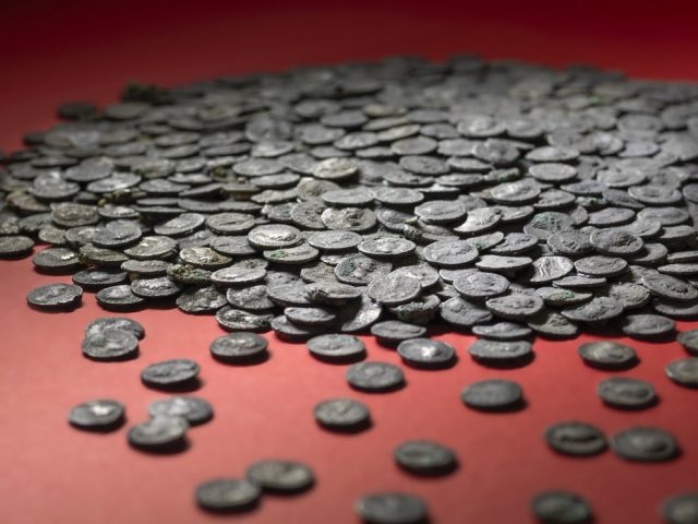 Pile of Roman-era silver coins atop a red table