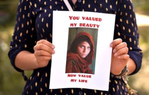 Woman holding the photograph of the 'girl with the green eyes'