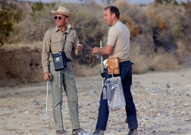 Fred Haise and Jim Lovell standing in the desert