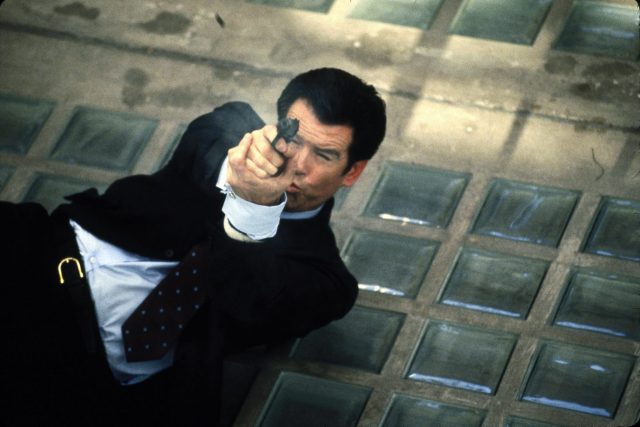 James Bond lying on his back, pointing his handgun toward the sky