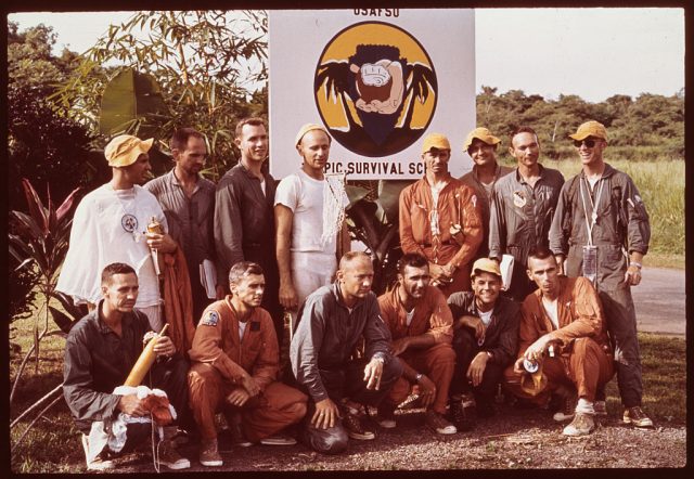 NASA astronauts standing before the United States Air Force Jungle Survival School sign