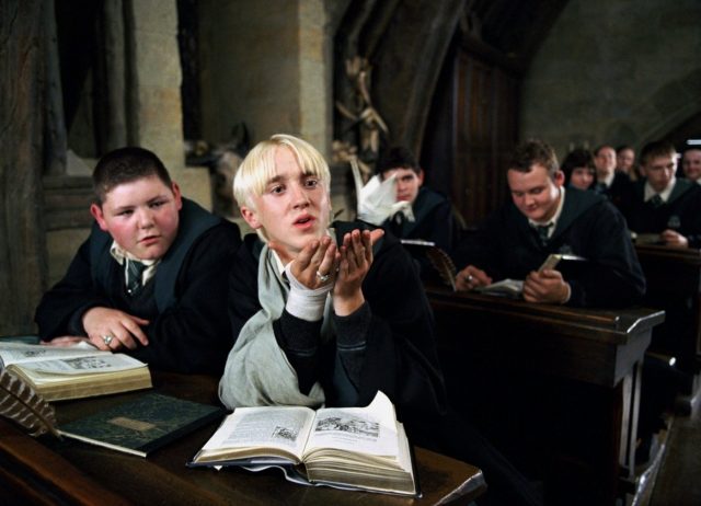 Vincent Crabbe watching as Draco Malfoy sends Harry Potter an origami swan