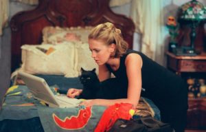 Sabrina Spellman and Salem looking at a laptop