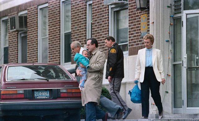 William Stern, biological father of Baby M carries the infant from the Conklin home where the biological mother, Mary Beth Whitehead, was able to visit the infant on the last day of the first week of the trial to determine custody. (Photo Credit: Bettmann / Contributor)