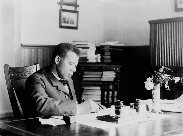 Booker T. Washington sitting at his desk