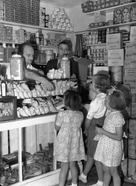 Three young girls standing at the counter of a candy store