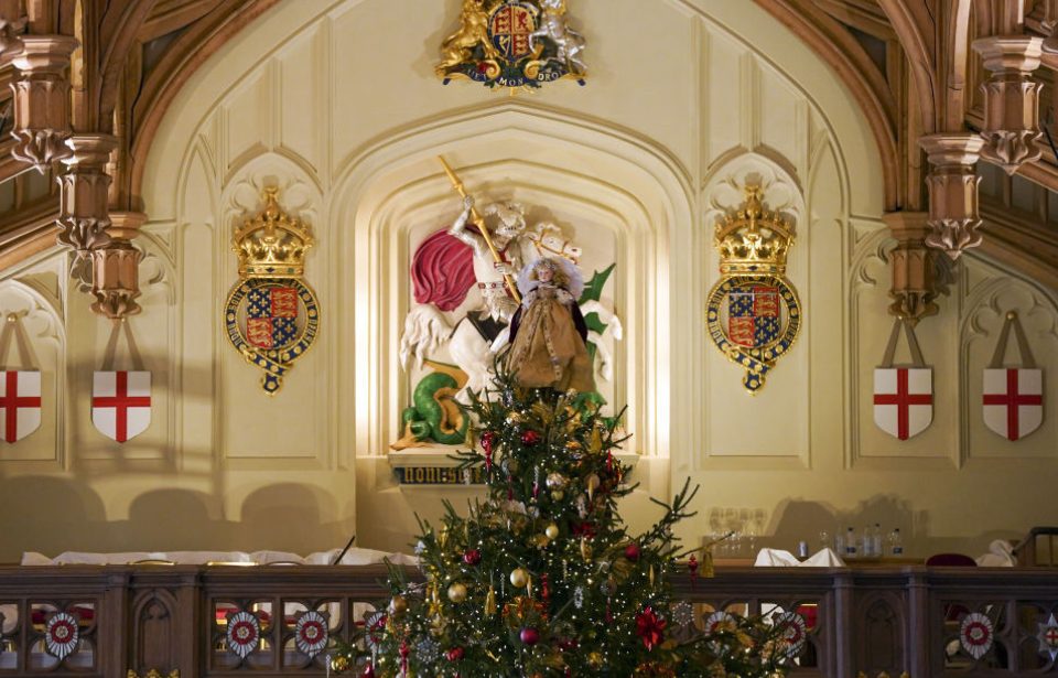 Members of the Royal Collection Trust staff put the finishing touches to a Christmas tree in St George's Hall, which is part of the Royal Collection's The Princesses' Pantomimes costume display and Christmas decorations at Windsor Castle. (Photo Credit: Steve Parsons/PA Images via Getty Images)