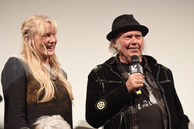 Daryl Hannah and Neil Young standing together with microphones