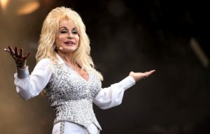 Dolly Parton holding up her arms