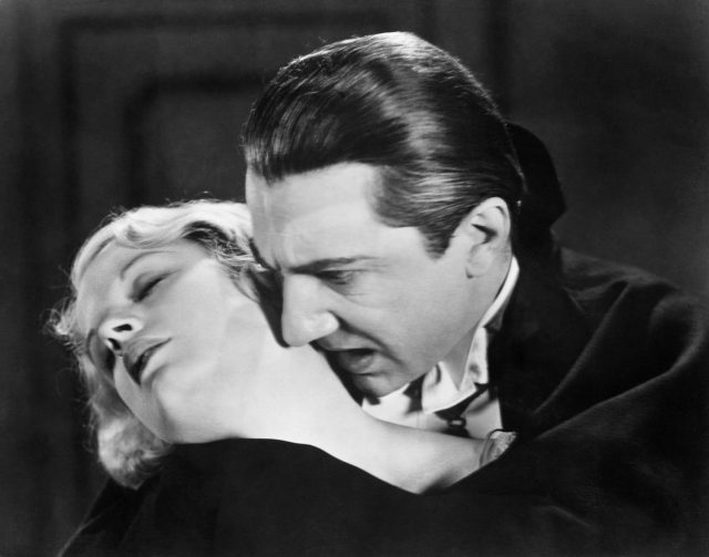 Count Dracula leaning in to bite Mina Seward's neck