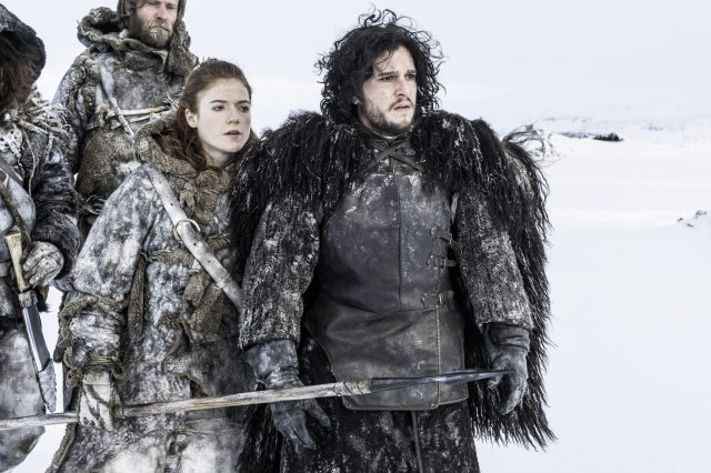 Jon Snow and Ygritte standing in the snow with others