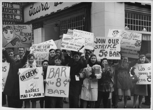 Children holding signs protesting the price of chocolate bars