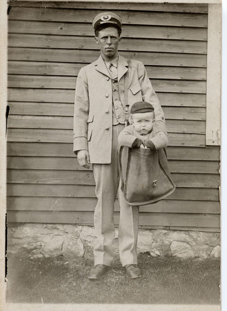 Postman with a small boy in his mailbag