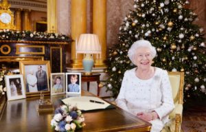 Queen Elizabeth II sits at a desk