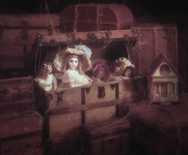 five dolls in a wooden chest