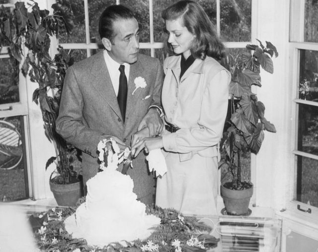 Married American actors Lauren Bacall and Humphrey Bogart cut the cake at their wedding. (Photo Credit: Hulton Archive/Getty Images)