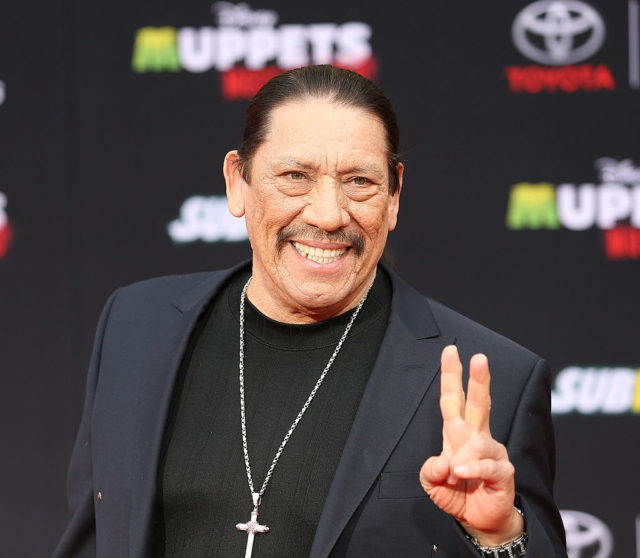 Danny Trejo flashes the peace sign