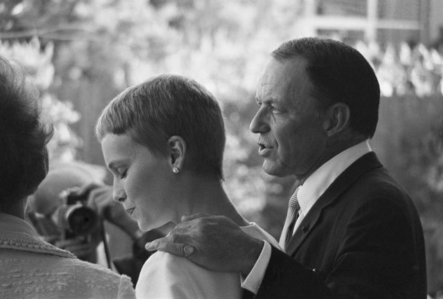 Mia Farrow seems flattered by the attention as singer Frank Sinatra introduces her as his wife following their marriage at the Sands Hotel. (Photo Credit: Bettmann / Contributor)