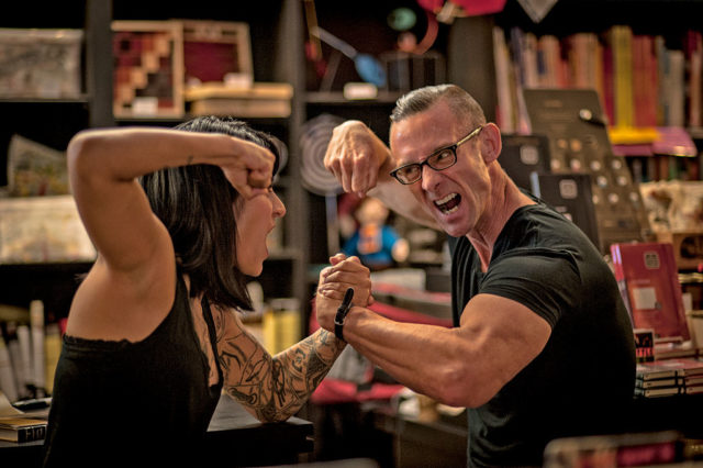 Chuck Palahniuk fight poses with a fan
