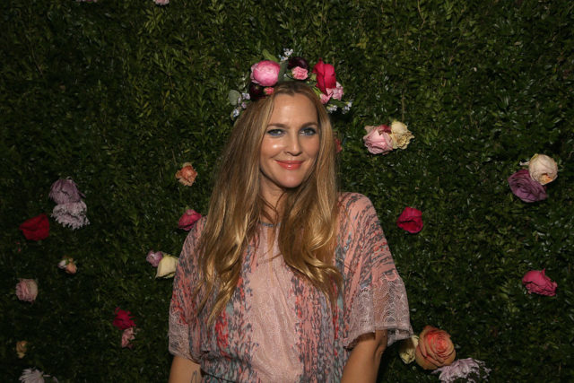 Drew Barrymore in front of a wall of flowers