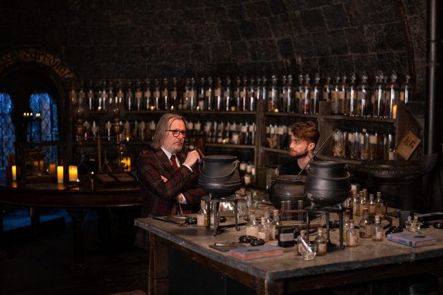 Gary Oldman and Daniel Radcliffe sitting in Professor Snape's Potion's classroom