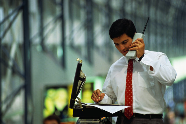 businessman talking on an old cell phone 
