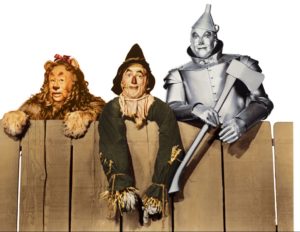 The Cowardly Lion, Scarecrow and the Tin Man leaning over a wooden fence