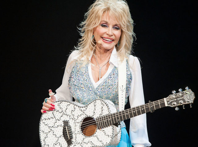 Dolly Parton holding her guitar