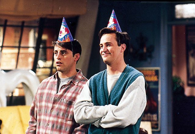 Joey Tribbiani and Chandler Bing wearing party hats
