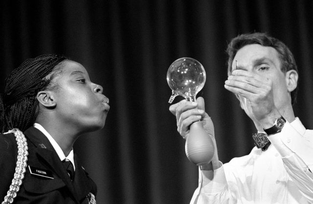 The students at Springbrook High were entertained by Bill Nye, the science guy. Here Nye uses a globe to demonstrated aerodynamics by having student Debbie Faderin, a member of Junior ROTC, blow out a candle on the other side of the globe (Photo Credit: Susan Biddle/The The Washington Post via Getty Images)