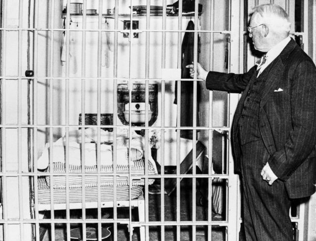 Warden James A. Johnston pointing into a cell