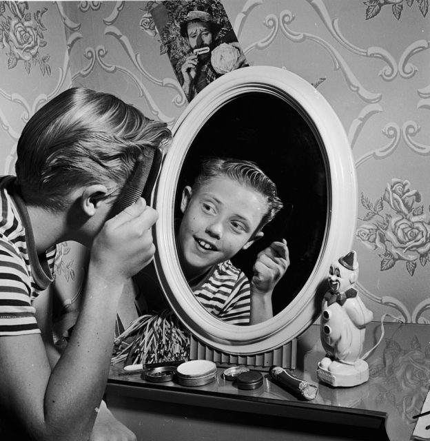 combing his hair in the mirror