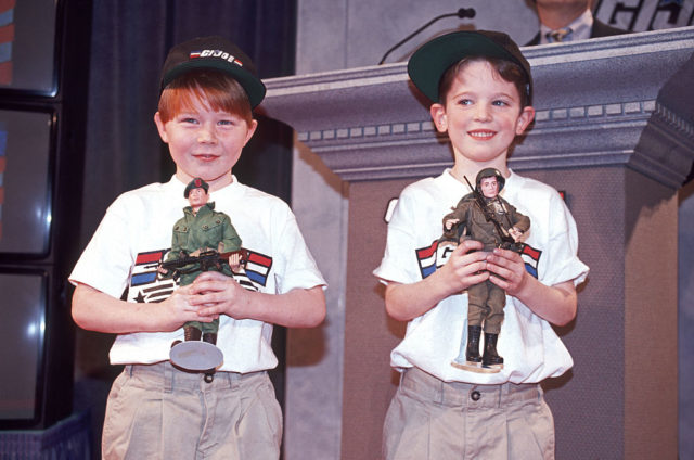 Two young boys holding G.I. Joe action figures