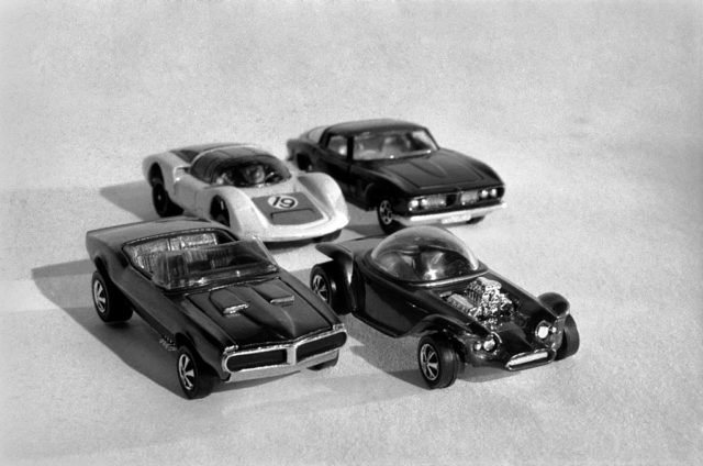 Four Hot Wheels cars lined up in rows of two