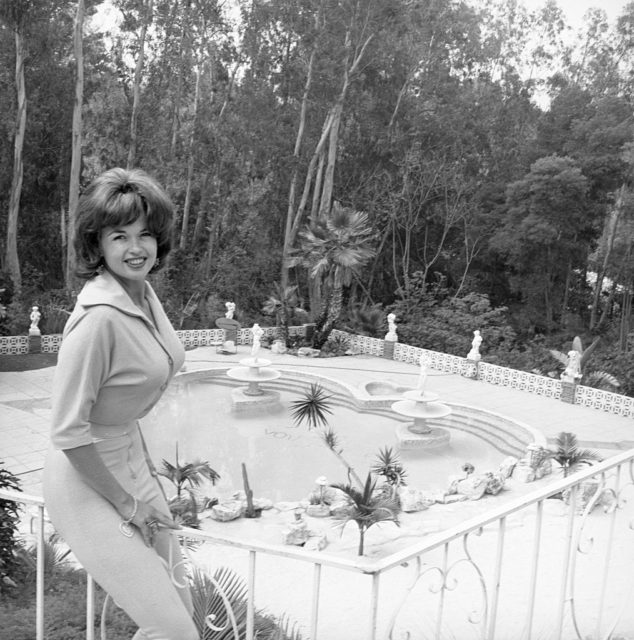 Jayne Mansfield poses with her heart-shaped pool in the backyard of her Pink Palace 
