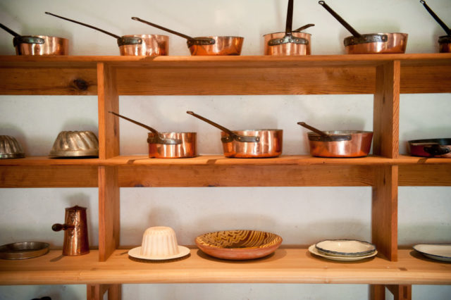 Shelves of copper pots and pans i