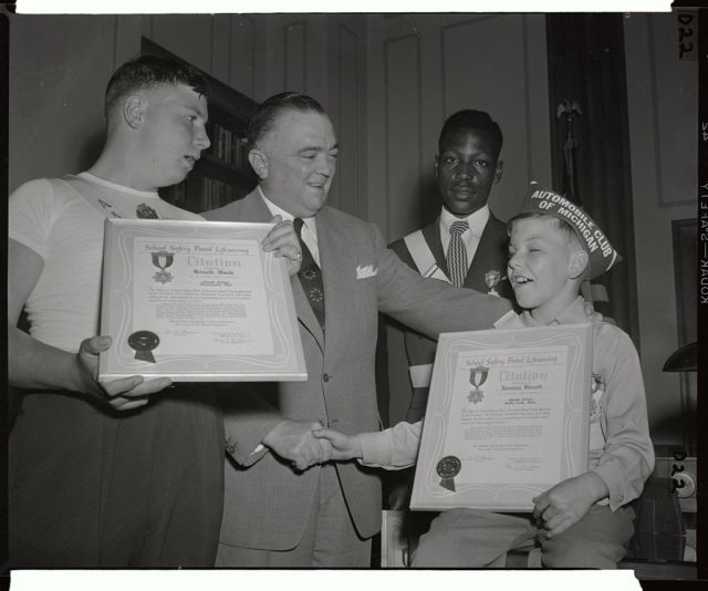 J. Edgar Hoover presenting certificates to three male members of the School Safety Patrol