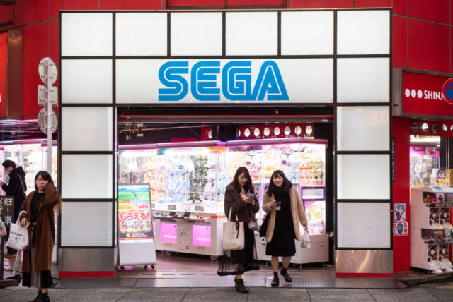Two women walking out of a SEGA Entertainment arcade