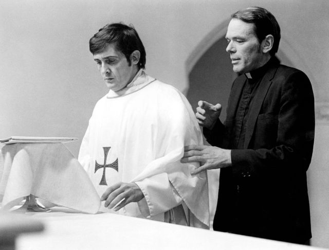 Father Damien Karras and Father Dyer standing at a church altar