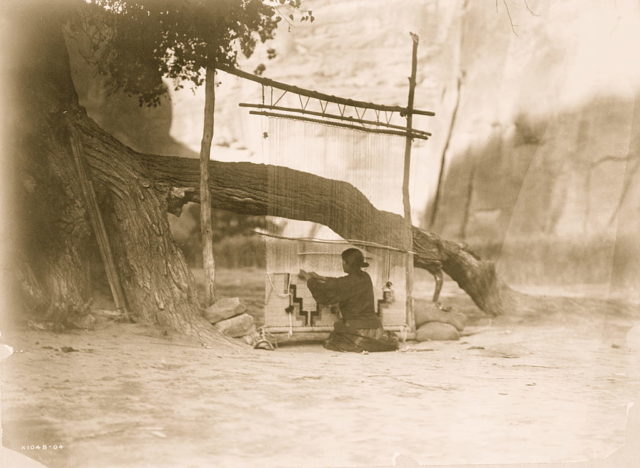 Navajo woman weaving a blanket 