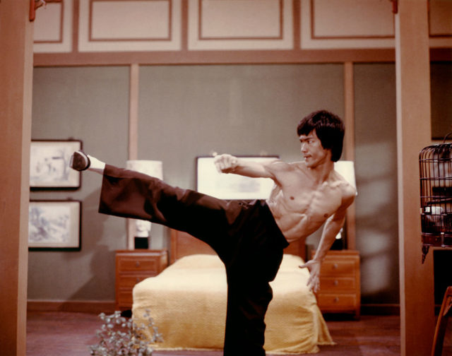 Bruce Lee performs a kick while filming Enter The Dragon 