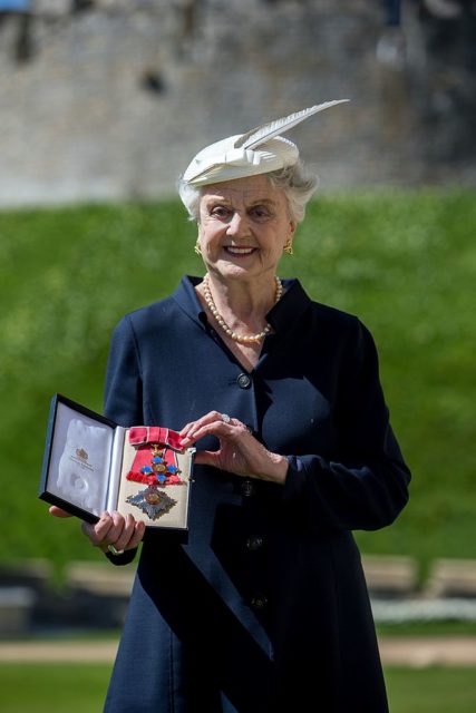 Lansbury poses with the DBE medal given to her by Queen Elizabeth II