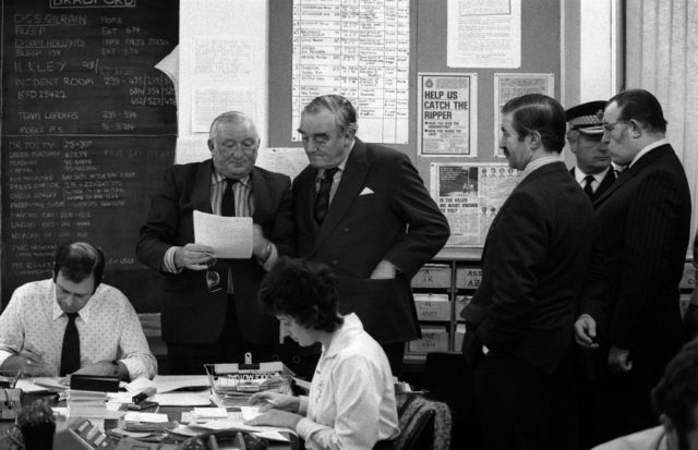 William Whitelaw standing with investigators in the incident room of the Yorkshire Ripper investigation